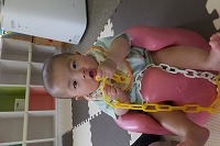 座ってプラスチックのチェーンで遊ぶ男の子