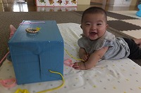 箱の前で笑っている男の子