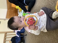 玩具をなめている９か月の女の子