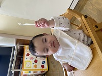 フォークを持って喜んでいる９か月の女の子
