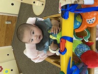 テーブルイスに座って玩具で遊ぶ男の子