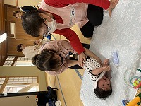 助産師に抱き方を教えてもらうお母さん