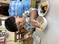 アイスにトッピングをしている子ども