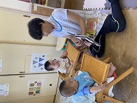 イスに並んで座っている男の子と女の子と先生