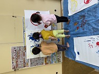 壁に貼った紙にダイナミックに描いている子ども達