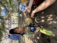 先生から砂で作ったお団子をもらって喜んでいる男の子