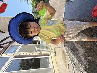 じょうろから出てくる水の動きを見ている男の子