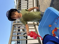 じょうろで水をかけて楽しんでいる男の子