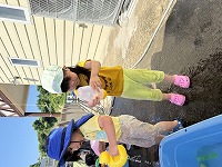 容器を手で押して水を出そうとしている女の子