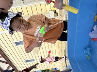 水を別の容器に移し替えている男の子