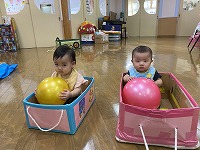 ボールをもって段ボール箱に入っている男の子と女の子