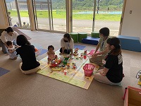 柔らかいマットの上にある玩具で遊ぶ子どもたち