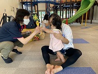 名前を呼ばれて先生とハイタッチしている８ヶ月女児