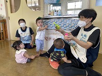 しゃぼん玉を飛ばす先生に集まる子ども達