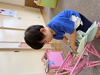 ベビーカーに人形を入れてお世話している男の子