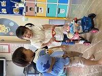 会話しながら人形をお散歩させている男の子と女の子