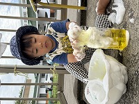 泡に黄色の色水を混ぜている男の子