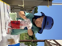 カップに色水を入れてジュースを作っている男の子