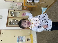 片手を上げてニッコリ笑う女の子