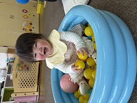 小さなボールプールに入って遊ぶ赤ちゃん
