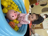 小さなボールブールの中に入って遊ぶ赤ちゃん