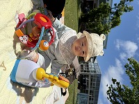 青空の下、玩具で遊ぶ赤ちゃん