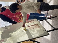 ひな人形を飾る手伝いをする子ども