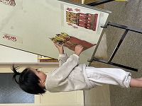 ひな人形を飾る手伝いをする子ども