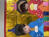 お内裏様とお雛様の顔パネルで２ショットを撮る子ども