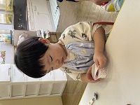 ゼリーのふたをはがす子ども