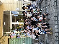 笹飾りの前で笑顔の先生と子どもたち