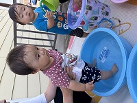 水が入ったタライに足を入れる赤ちゃん