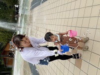 お母さんと噴水から出る水をくもうとしている