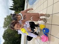 お母さんと水を注ぐ女の子