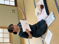 ベビーマッサージについて説明する講師の先生
