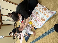 顔をマッサージしてもらう赤ちゃん