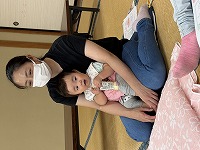 ママの膝に座ってマッサージを受ける赤ちゃん