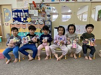 もらったプレゼントをもって記念撮影をする卒園児