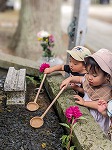 水かけ地蔵に水をかける子ども