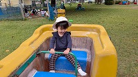 公園の遊具に乗って笑っている子ども