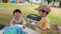 カエルをみせてもらってびっくりしている子ども