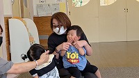 おばあさんと一緒に遊んでいる子ども