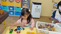車を並べて遊んでいる子ども