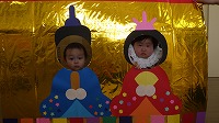 お内裏様とお雛様の顔パネルで２ショットを撮る子ども