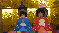 お内裏様とお雛様の顔パネルで２ショットを撮る子ども