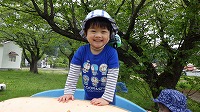 すべり台の上からヤッホーと言っている男の子