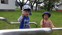 鉄棒を木の枝でカンカンをたたいている男の子達