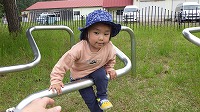 鉄棒に足をひっかけている男の子