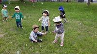 公園でしゃぼん玉を追いかけている子ども達