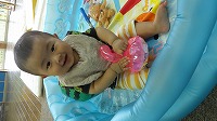 プールに座ってニコニコする男の子